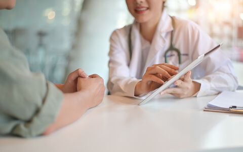 Eine ausführliche Aufklärung über das Erkrankungsbild ist wichtig bei akuter Porphyrie. Ärztin klärt Patient über die Erkrankung akute Porphyrie auf.